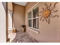 Cozy exterior nook with a decorative sunburst accent, a large window, and potted plants enhancing the outdoor ambiance at 4247 James River Cir, Leesburg, FL 34748