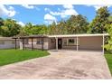 Charming single story home boasts a large covered carport, pergola, and lush green lawn at 4251 Magnolia Ave, Leesburg, FL 34748