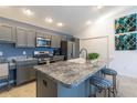 Modern kitchen with gray cabinets, stainless steel appliances, and a spacious center island at 463 Kayla Ct, The Villages, FL 32163