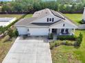 Aerial view of a single-story home with a three-car garage, large driveway, and fenced yard at 485 Halter Dr, Apopka, FL 32712