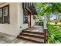 Inviting front porch with awning and lush greenery framing the entrance at 545 W Cummings St, Lake Alfred, FL 33850