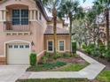 Charming exterior view featuring an attached garage, lush landscaping and tile roof at 602 Camino Real Blvd # 602, Howey In The Hills, FL 34737