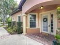 Inviting front entrance with brick walkway, lovely landscaping, and classic wreath on the front door at 602 Camino Real Blvd # 602, Howey In The Hills, FL 34737