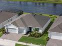 Aerial view of house boasting brick driveway, gray roof, & manicured lawn at 6308 Mossy Oak Rd, St Cloud, FL 34771