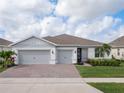Charming home with a three-car garage, brick driveway and well-manicured lawn at 6308 Mossy Oak Rd, St Cloud, FL 34771