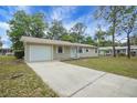 A cozy single-story home with a well-kept lawn and a convenient attached garage at 74 Stone Haven Ct, Leesburg, FL 34788