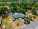 Aerial view of a beautiful property featuring a pool and surrounded by lush greenery, offering a private oasis at 8198 Se 164Th Pl, Summerfield, FL 34491