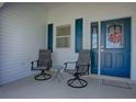Relaxing front porch with two swivel chairs and a small table, perfect for enjoying the outdoors at 1010 Ventura Dr, The Villages, FL 32159