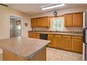 Well-equipped kitchen boasts ample cabinet space, tile floors, and a convenient center island, perfect for meal preparation at 10166 Cr 671, Bushnell, FL 33513