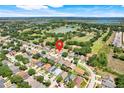 An aerial view of a neighborhood with homes surrounded by lush greenery, lakes, and community amenities at 1159 Greenley Ave, Groveland, FL 34736