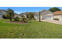 Well-maintained front yard with a lush lawn, palm trees, and neat landscaping enhancing the curb appeal of the home at 11860 Se 179Th St, Summerfield, FL 34491