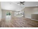 Open-concept living room with hardwood floors, modern lighting, and sliding glass doors to the backyard at 12817 Sw 77Th Cir, Ocala, FL 34473