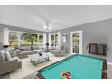 Spacious living room featuring a pool table, neutral decor, and lots of natural light at 132 Palermo Pl, The Villages, FL 32159