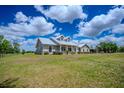 Well-maintained single-story home featuring a metal roof and a spacious front yard at 15141 Farm Rd, Groveland, FL 34736