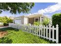 Delightful home with charming curb appeal, featuring a white picket fence, attractive landscaping, and a cozy screened lanai at 1667 Osprey Ave, The Villages, FL 32162