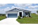 Inviting single-story home featuring a lush green lawn, attractive landscaping, and an attached garage at 1688 Littleleaf Boxwood Loop, Mascotte, FL 34753