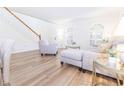 Bright living room with wood floors, neutral-toned furniture, and ample natural light from arched windows at 1704 Hoofprint Court, Fruitland Park, FL 34731