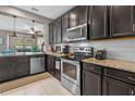 This well-appointed kitchen features stainless steel appliances, granite countertops and dark wood cabinets at 17519 Promenade Dr, Clermont, FL 34711