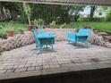 Cozy brick patio with blue outdoor seating and lush green landscaping at 1765 Hilltop Dr, Mount Dora, FL 32757