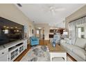 Open living room featuring wood floors, a large television, comfortable seating, and natural light at 2064 Edenton Ter, The Villages, FL 32162