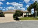 Beautiful home with a two-car garage, mature palms, and manicured front yard at 2071 Westchester Way, The Villages, FL 32162