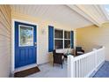 Inviting front porch with a blue door, cozy seating, and stylish decor, offering a warm welcome at 2290 Due West Dr, The Villages, FL 32162