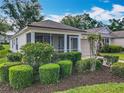 This single story home features a well-maintained lawn with neatly trimmed shrubs at 25044 Cranes Roost Cir, Leesburg, FL 34748