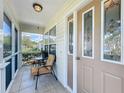 Close up of a screened in front porch with tile flooring and seating at 25044 Cranes Roost Cir, Leesburg, FL 34748