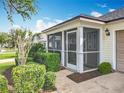 The home has a screened in front porch with neutral trim and a storm door at 25044 Cranes Roost Cir, Leesburg, FL 34748