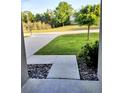 Inviting front yard featuring a manicured lawn and concrete driveway, creating a welcoming entrance at 27 Perch Dr, Kissimmee, FL 34759