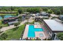 A bird's-eye view shows a shared pool and spa with palm trees and multiple buildings nearby at 2934 Tangerine Ct, Leesburg, FL 34748