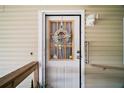 Charming front door adorned with a welcoming floral wreath, complemented by well-maintained exterior at 3209 Manatee Rd, Tavares, FL 32778