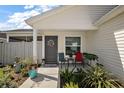 Covered front porch with a seating area, potted plants, and a welcoming entrance at 3222 Miller Stachler St, The Villages, FL 32163