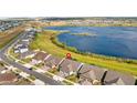 Aerial view of beautiful homes near a scenic lake with a marker indicating the property location at 3256 Canna Lily Pl, Clermont, FL 34711