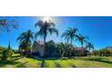 Lovely home exterior with palm trees, luscious green lawn, and sunny blue skies at 3511 Fox Lake Dr, Apopka, FL 32712