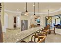 Open kitchen bar area with granite countertops, stainless steel appliances, and casual seating at 39705 Grove Hts, Lady Lake, FL 32159