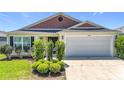 Attractive single-story home with a two-car garage and manicured shrubs at 449 Gilson Loop, The Villages, FL 32163