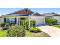 Well-kept single-story home with a two-car garage and lush green lawn at 449 Gilson Loop, The Villages, FL 32163