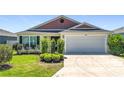 Inviting single-story home with a well-manicured lawn and mature landscaping at 449 Gilson Loop, The Villages, FL 32163