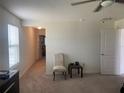 Bright bedroom featuring neutral carpeting, a ceiling fan, and a large window at 709 Sarner Pass Way, Winter Haven, FL 33881