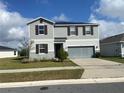 Charming two-story home with gray siding, shutters, and a well-maintained lawn at 709 Sarner Pass Way, Winter Haven, FL 33881
