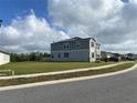 Exterior view of a two-story home with gray siding and a spacious lawn at 709 Sarner Pass Way, Winter Haven, FL 33881