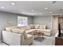 Inviting living room with marble tile floors, recessed lighting, a neutral sectional and a bright window at 726 S Stone St, Deland, FL 32720