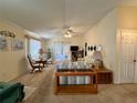 Open living room with carpet, ceiling fan and light, French doors, and neutral color palette at 728 Ramirez Ave, The Villages, FL 32159
