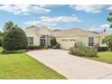 Lovely single-story home with a well-manicured lawn, flowerbeds, and an attached two-car garage at 8043 Pine Hollow Dr, Mount Dora, FL 32757