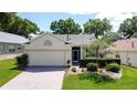 Charming single-story home features a brick driveway and meticulously landscaped front yard, with attached two-car garage at 860 Wolf Creek St, Clermont, FL 34711