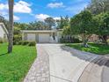 Charming single-story home featuring a decorative driveway, manicured lawn, and covered entryway at 1105 Del Toro Dr, The Villages, FL 32159