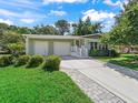Beautiful single-story home featuring a two-car garage, mature landscaping and sidewalk at 1105 Del Toro Dr, The Villages, FL 32159