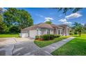 This home showcases a clean two-car garage and a well-manicured front yard with lush plantings at 11811 Ridge View Cir, Clermont, FL 34711