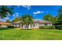 Beautiful home featuring well-maintained landscaping with palm trees and large windows for natural light at 11811 Ridge View Cir, Clermont, FL 34711